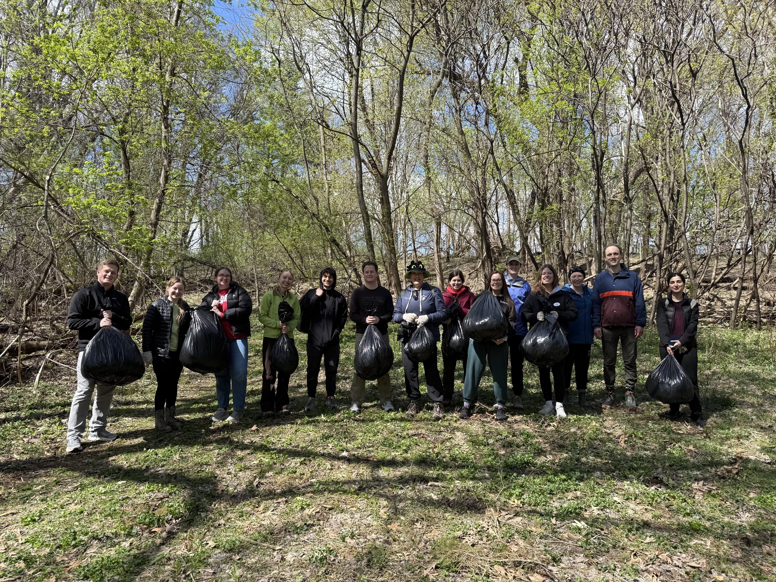 Group photo of volunteers holding trash bags filled with invasive garlic mustard after Green Offices Go Outside event at Lakeshore Nature Preserve